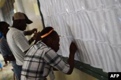 People look the voting lists at polling station at the Lycee National in the Petion Ville suburb of Port-au-Prince, Haiti, during the presidential and legislative elections, Nov. 20, 2016.