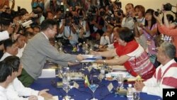 မီးရထားဝန္ႀကီးဦးေအာင္မင္း(ဝဲ)ႏွင့္ KNU အေထြေထြအတြင္းေရးမႉးေနာ္စီဖိုးရာစိန္(ယာ) ေဆြးေႏြးပဲြမွတ္တမ္းလဲလွယ္စဥ္။ (ဧၿပီလ ၆ ရက္၊ ၂၀၁၂။) 
