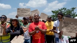 President of the General Industries Workers Union of South Africa Mametlwe Sebei, center, chants slogans while joining community members and workers in a protest during the rescue operation to retrieve illegal miners from an abandoned gold mine in South Africa on Jan. 14, 2024.