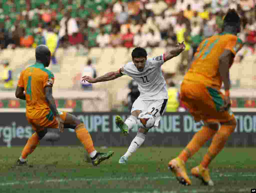 Egypt&#39;s Omar Marmoush, middle, kicks the ball as he attempts a goal shot during the match against Ivory Coast in Cameroon, Jan. 26, 2022.