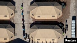 Niños migrantes son vistos en fila en un centro de detención en Tornillo, Texas, EE.UU., el 18 de junio de 2020.