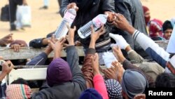 Fuyant les violences en Libye, des réfugiés se retrouvent dans un camps en Tunisie où de l'eau est distribuée, à Ras Jdir, le 9 mars 2011.