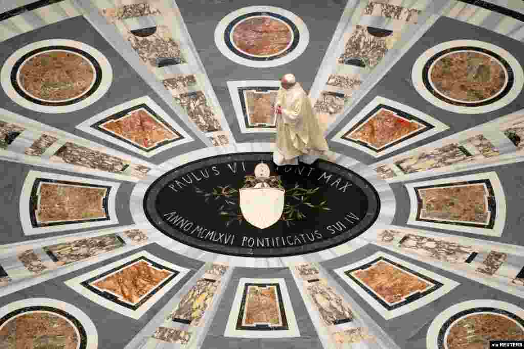 Pope Francis walks inside St. Peter's Basilica to lead a private Mass to commemorate the 100th anniversary of the late pope's birth, at the Vatican. (Credit: Vatican Media/­Handout)