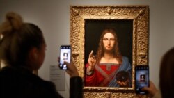 People take pictures of an oil painting by Leonardo da Vinci, "Salvator Mundi," during the opening of the exhibition "Leonardo da Vinci, " at the Louvre museum in Paris, France.