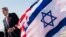 U.S. Secretary of State John Kerry walks past American and Israeli flags at Ben Gurion International Airport in Tel Aviv, Jan. 6, 2014.