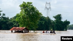 Para relawan mengarungi banjir dengan perahu untuk mencari korban selamat menyusul Badai Yagi di Kota Taungnoo, Myanmar, 17 September 2024. (Foto: Stringer/Reuters)