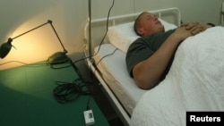 한 남성이 은은한 노래를 틀어서 숙면을 도와주는 베개를 체험하고 있다. (자료사진)
