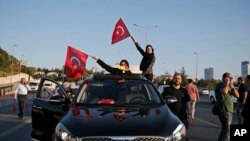 Des habitants de la capitale turque, accrochés aux fenêtres des véhicules, agitent les drapeaux nationaux après l’annonce par le gouvernement de la défaite de putschistes à Istanbul, Turquie, 16 juillet 2016. (AP Photo / Emrah Gurel)