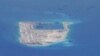 FILE - Chinese dredging vessels are purportedly seen around Fiery Cross Reef in the disputed Spratly Islands in the South China Sea in this image from video taken by a P-8A Poseidon surveillance aircraft provided by the U.S. Navy, May 21, 2015. 