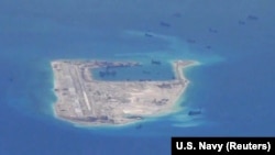 FILE - Chinese dredging vessels are purportedly seen around Fiery Cross Reef in the disputed Spratly Islands in the South China Sea in this image from video taken by a P-8A Poseidon surveillance aircraft provided by the U.S. Navy, May 21, 2015. 