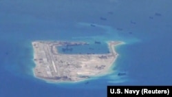 Chinese dredging vessels are purportedly seen around Fiery Cross Reef in the disputed Spratly Islands in the South China Sea in this image from video taken by a P-8A Poseidon surveillance aircraft provided by the U.S. Navy, May 21, 2015.