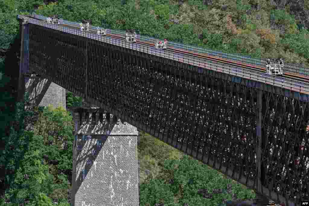 People cross the Viaduc des Fades as they ride the &#39;vélorail&#39; on an old railway line in Les Ancizes-Comps, central France, Aug. 18, 2020.