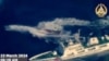 This photo from aerial video footage released March 23, 2024, by the Philippine military shows a Chinese coast guard ship deploying a water cannon against the Philippine civilian boat Unaizah May 4 near the Second Thomas Shoal in disputed waters of the South China Sea.