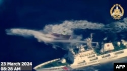 菲律宾武装部队2024年3月23日拍摄并发布的航拍视频截图显示，中国海警船（右下）使用水炮袭击菲律宾补给船。