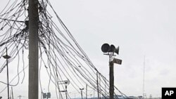 Men repair generators beneath a tangle of power lines, on the rooftops of electronics stores in Oshodi Market in Lagos, Nigeria, August 24, 2010.