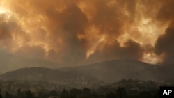 En esta fotografía de archivo del viernes 6 de agosto de 2021, el humo se extiende sobre la montaña Parnitha durante un incendio forestal en el pueblo de Ippokratios Politia, Grecia, a unos 35 kilómetros (21 millas) al norte de Atenas.