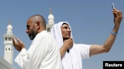 Seorang jemaah haji berdoa sementara yang lainnya melakukan swafoto atau selfie di Masjid Agung saat melakukan tawaf di Makkah. (Foto: Dok)