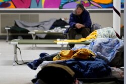 People seeking shelter from sup-freezing temperatures rest at a make-shift warming shelter at Travis Park Methodist Church, Feb. 16, 2021, in San Antonio.