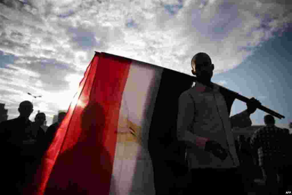 An Egyptian man sells flags in Tahrir Square in Cairo, Egypt, Thursday, Feb. 10, 2011. Mubarak refused to step down or leave the country and instead handed his powers to his vice president Thursday, remaining president and ensuring regime control over the