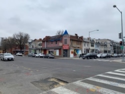 Cars park along the street near stores that remain open in the Park View neighborhood of Washington, D.C. (Chris Simkins/VOA)