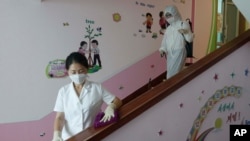 30일 북한 평양의 한 초등학교에서 신종 코로나바이러스 감염 예방을 위해 방역 요원이 계단을 소독하고 있다. 