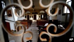 FILE - The altar of Judeida church is seen damaged by mortar shell, at the Christian village of Judeida, in Idlib province, Syria. 