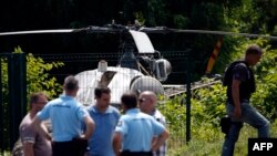 Polisi berdiri di dekat sebuah helikopter yang ditinggalkan oleh gangster terkenal, Redoine Faid, di Gonesse, utara Paris, setelah melarikan diri dari penjara di Reau, Perancis, 1 Juli 2018. (Foto: dok)