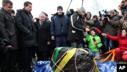 People look at what scientists believe to be is a chunk of the Chelyabinsk meteor, recovered from Chebarkul Lake near Chelyabinsk, about 1500 kilometers east of Moscow on October 16, 2013.