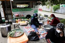 Relawan "Dompet Dhuafa" menyiapkan makanan bagi pasien COVID-19 yang melakukan isolasi mandiri di Tangerang, Banten (11/7).