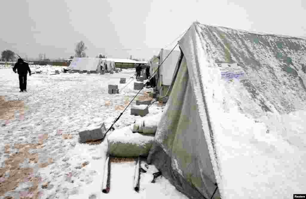 Syrian refugees stand in snow outside their tents during a winter storm in al-Marj, in the Bekaa valley, Lebanon, January 9, 2013.