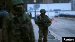 Pasukan bersenjata terlihat berpatroli di bandara Simferopol di Krimea, Ukraina (28/2), yang digambarkan oleh pemimpin baru Ukraina sebagai intervensi Moskow. 