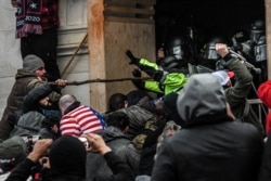 FILE - Supporters of then-President Donald Trump clash with police at the west entrance of the Capitol building in Washington, Jan. 6, 2021. Off-duty police officers from various jurisdictions were found to have been among those storming the Capitol.