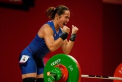 Hidilyn Diaz celebrates after a lift as she competes in the women's 55kg weightlifting event, at the 2020 Summer Olympics, , July 26, 2021, in Tokyo.