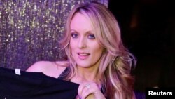 Adult-film actress Stephanie Clifford, also known as Stormy Daniels, poses for pictures at the end of her show at the Gossip Club in Long Island, New York, Feb. 23, 2018. 