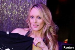 FILE - Adult-film actress Stephanie Clifford, also known as Stormy Daniels, poses for pictures at the end of her show at the Gossip Club in Long Island, New York, Feb. 23, 2018.