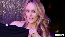 Adult-film actress Stephanie Clifford, also known as Stormy Daniels, poses for pictures at the end of her show at the Gossip Club in Long Island, New York, Feb. 23, 2018.