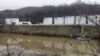 Workers inspect an area outside a retaining wall around storage tanks where a chemical leaked into the Elk River at Freedom Industries storage facility in Charleston, West Virginia, Jan. 13, 2014. 