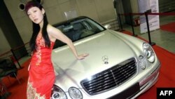资料照：一名中国模特在北京举行的汽车展上为奔驰汽车做广告。