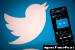FILE - An illustration photo taken Oct. 26, 2020, shows the Twitter logo displayed on the screen of a smartphone and a tablet in Toulouse, France.