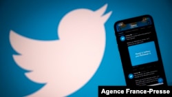 FILE - An illustration photo taken Oct. 26, 2020, shows the Twitter logo displayed on the screen of a smartphone and a tablet in Toulouse, France.