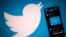 FILE - An illustration photo taken Oct. 26, 2020, shows the Twitter logo displayed on the screen of a smartphone and a tablet in Toulouse, France.