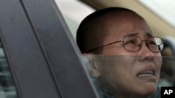 FILE - Liu Xia, wife of imprisoned Nobel Peace Prize winner Liu Xiaobo, cries in a car outside Huairou Detention Center where her brother Liu Hui has been jailed in Huairou district, on the outskirts of Beijing, China.