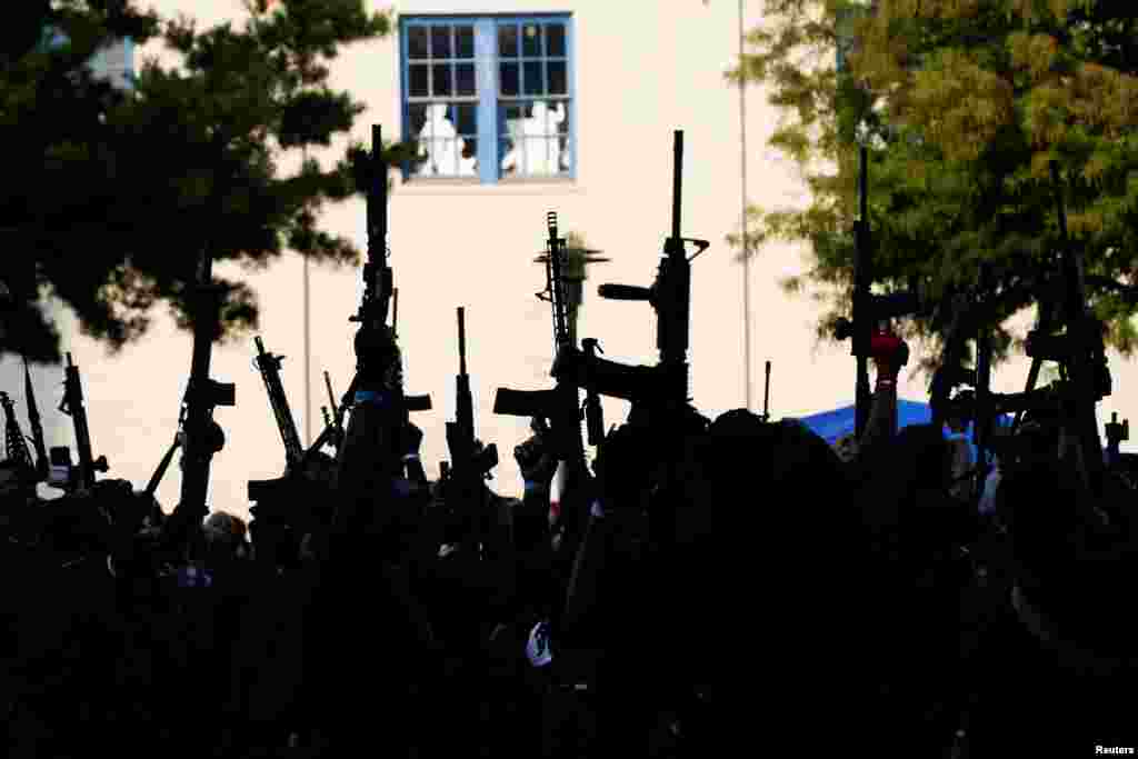 Members of a Black militia group called the NFAC raise their guns during an armed rally at Parc Sans Souci in Lafayette, Louisiana, Oct. 3, 2020.