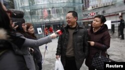 Los medios de comunicación entrevistan a un feliz comprador de un iPhone 5 en China.