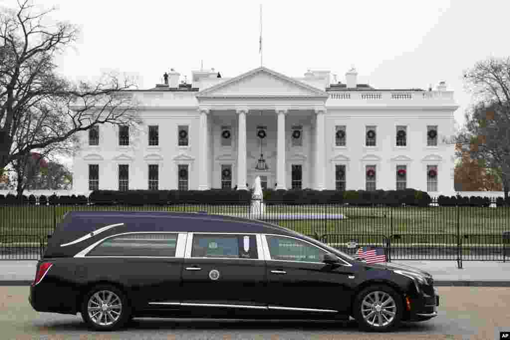 The hearse carrying the flag-draped casket of former President George H.W. Bush passes by the White House, heading to the National Cathedral, Dec. 5, 2018, in Washington.