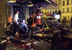 FILE - Victims of a shooting attack lay on the pavement outside La Belle Equipe restaurant in Paris, Nov. 13, 2015.