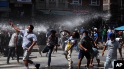 Nepalese protesters defying a government coronavirus lockdown to take part in a religious festival clash with riot police, in Lalitpur, Nepal, Sept. 3, 2020.
