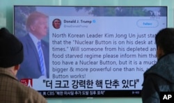 People watch a TV news program showing the Twitter post of U.S. President Donald Trump in Seoul, South Korea, Jan. 3, 2018. Trump said that he has a bigger and more powerful "nuclear button" than North Korean leader Kim Jong Un.