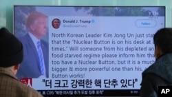 People watch a TV news program showing the Twitter post of U.S. President Donald Trump in Seoul, South Korea, Jan. 3, 2018. Trump boasted that he has a bigger and more powerful "nuclear button" than North Korean leader Kim Jong Un. 