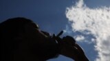 Muškarac puši marihuanu na neformalnoj proslavi kanabisa u Vašington skver parku u Njujorku, 20. aprila 2024.
